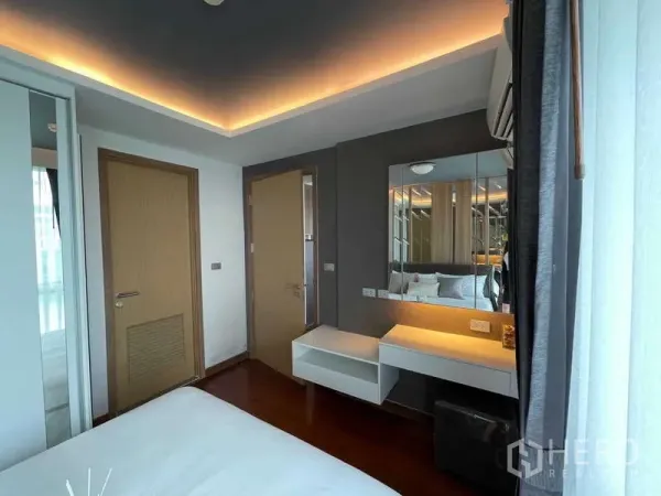 คอนโด ขายในWatthana, Bangkok - มุมห้องนอนพร้อมโต๊ะเครื่องแป้งลอยตัว กระจกเงาบานใหญ่ และไฟซ่อนใกล้หน้าต่าง