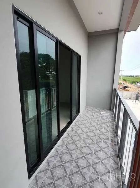 货栈 出租在Pathum Thani - 二层阳台，推拉玻璃门与花纹地砖