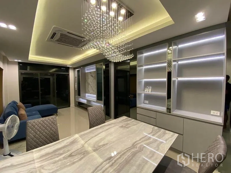 Detached House for rent - Dining area with crystal chandelier, LED-lit shelves and marble table.