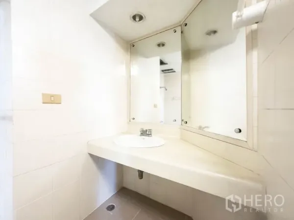 คอนโด ขายในBang Na, Bangkok - ห้องน้ำพร้อมเคาน์เตอร์อ่างล้างหน้าและกระจกเข้ามุม.