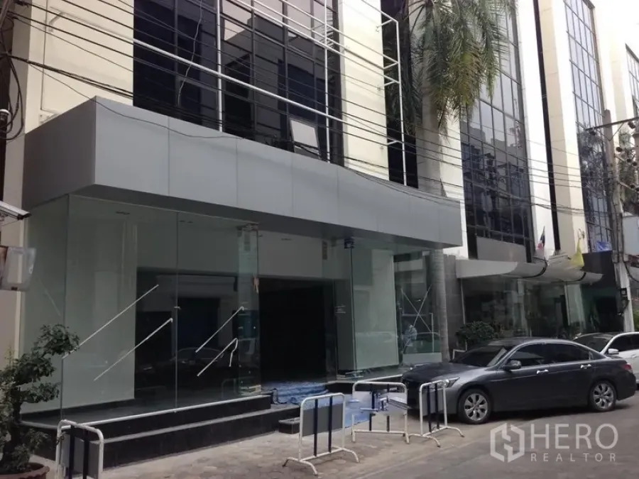 สำนักงาน ให้เช่าในBang Kapi, Bangkok - ทางเข้าอาคารสำนักงานกระจกสมัยใหม่ พร้อมพื้นที่รับ–ส่งรถ บนถนนในกรุงเทพฯ.