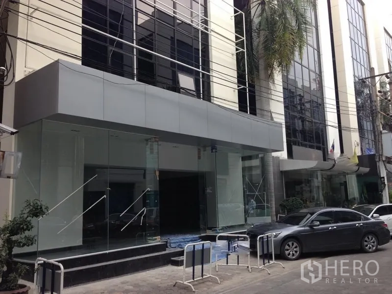 สำนักงาน ให้เช่าในBang Kapi, Bangkok - ทางเข้าอาคารสำนักงานกระจกสมัยใหม่ พร้อมพื้นที่รับ–ส่งรถ บนถนนในกรุงเทพฯ.