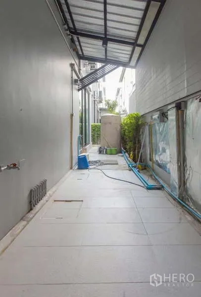 独立式住宅 出租或出售在Lat Phrao, Bangkok - 侧边带顶棚的生活阳台，铺砖地面，水箱与洗衣接口。