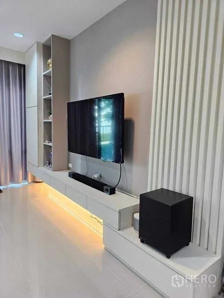 独立式住宅 出售在Khan Na Yao, Bangkok - 电视墙特写，悬浮柜与层板，地脚灯暖色氛围。