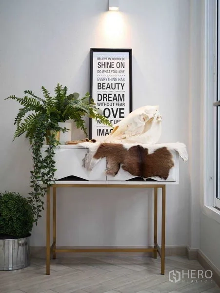 ทาวน์เฮาส์ ให้เช่าในWatthana, Bangkok - มุมคอนโซลตกแต่งด้วยงานศิลป์และต้นไม้ภายในบ้านใต้ไฟส่อง