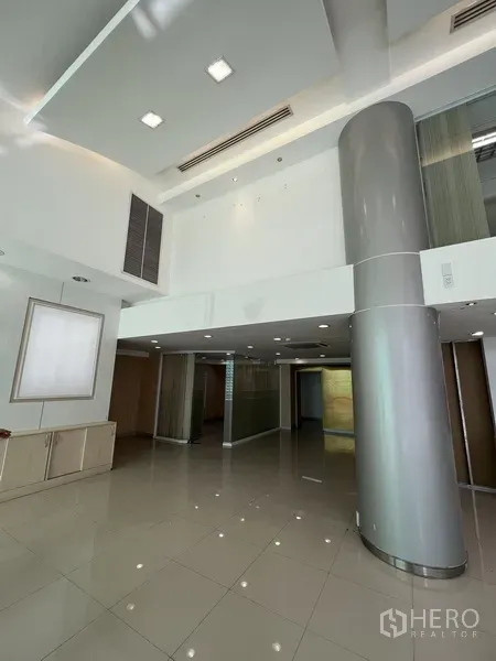 零售空间 出租在Huai Khwang, Bangkok - 展厅一角，超高天花、圆柱与嵌灯照明。