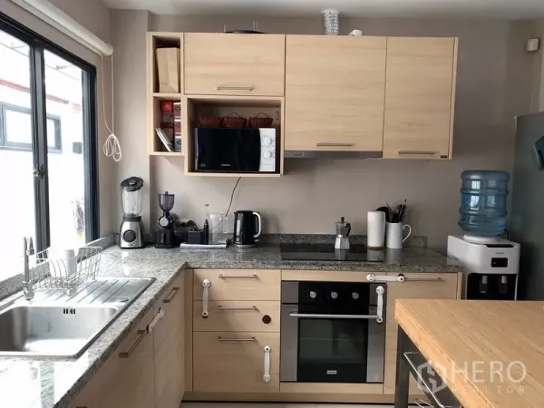 ทาวน์เฮาส์ ให้เช่าในKhlong Toei, Bangkok - ครัวรูปตัวแอล ท็อปหินแกรนิต เตาอบบิวท์อิน และเครื่องใช้ไฟฟ้า