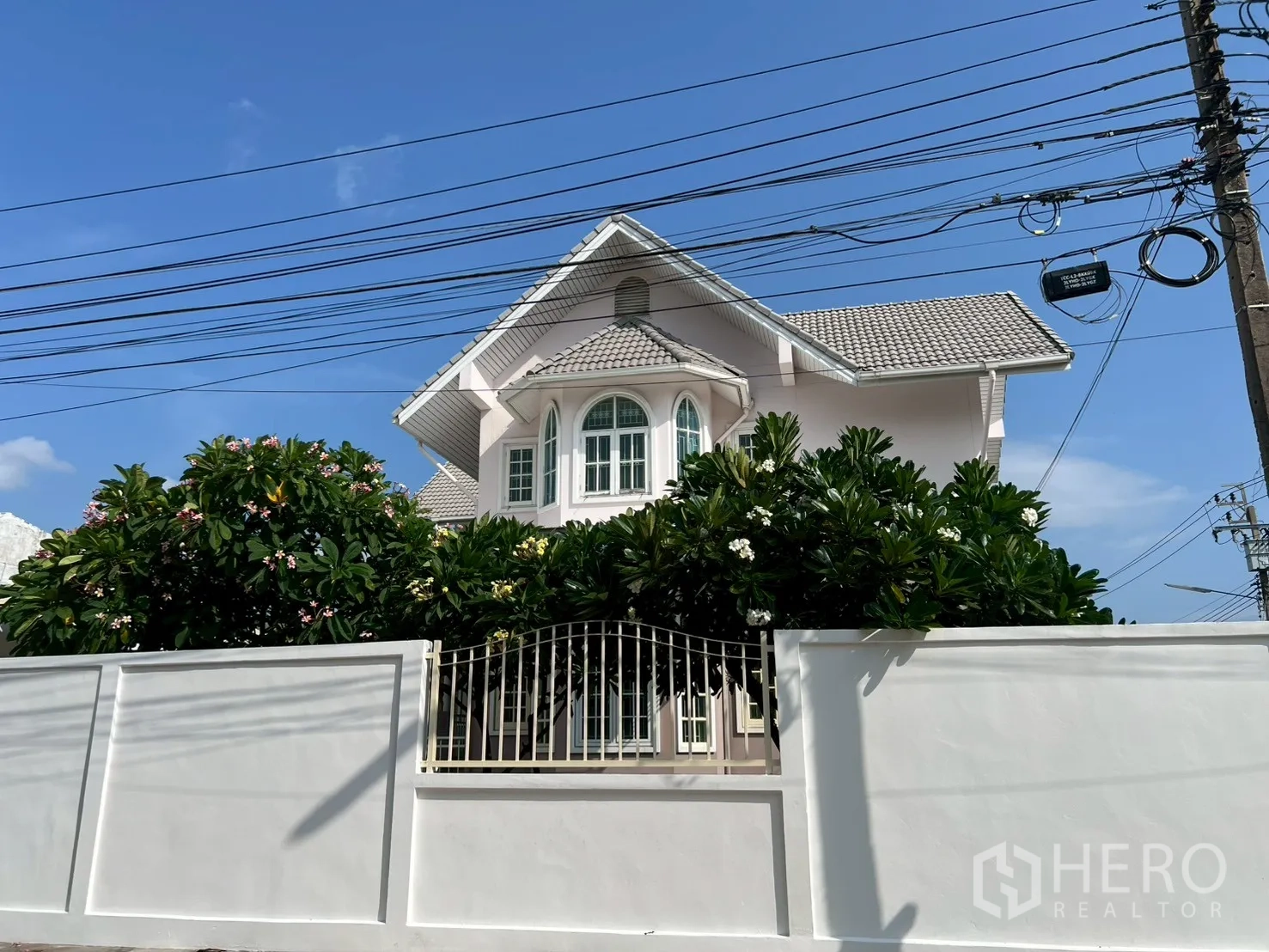 บ้าน ขายในPhra Khanong, Bangkok - ด้านหน้าบ้านพ้นกำแพงสีขาว มีไม้ดอกล้อมรอบ