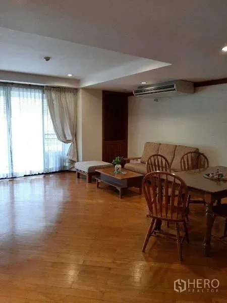 อพาร์ทเมนท์ ให้เช่าในWatthana, Bangkok - ห้องรับแขกแบบเปิดโล่ง มีโซฟา แอร์ และประตูบานเลื่อนออกสู่ระเบียง