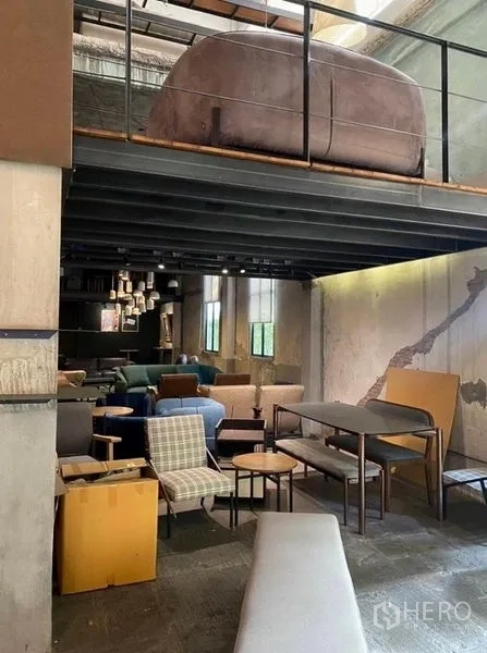Retail Space for rent in Bang Na, Bangkok - Ground-floor seating beneath a mezzanine with exposed concrete walls