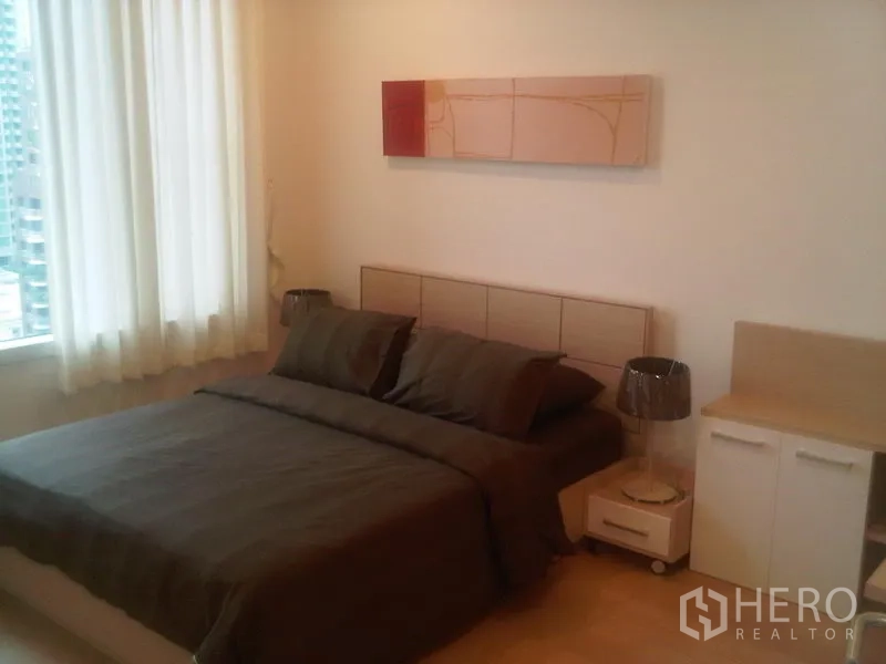 公寓 出售在Ratchathewi, Bangkok - 卧室配双人床与床头柜，大窗户和墙面装饰画，采光良好。