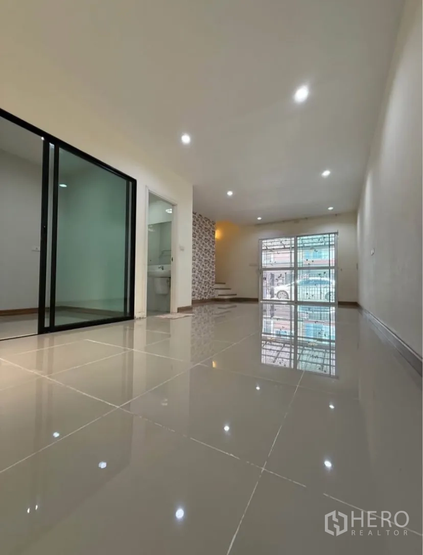 ทาวน์เฮาส์ ให้เช่าในSuan Luang, Bangkok - ห้องนั่งเล่นชั้นล่างสว่าง พื้นกระเบื้องเงา และประตูกระจกบานเลื่อน