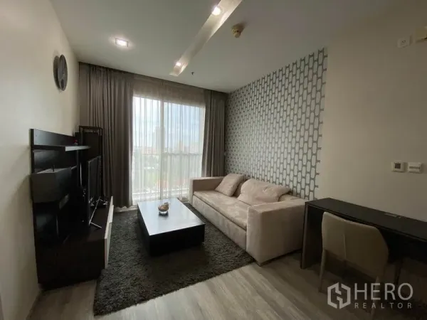 คอนโด ให้เช่าหรือขายในKhlong Toei, Bangkok - ห้องนั่งเล่นโปร่งสบายมีโซฟา ชั้นวางทีวี โต๊ะทำงาน และหน้าต่างระเบียงวิวเมือง