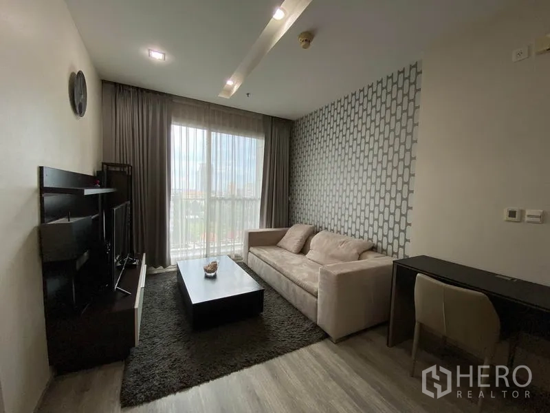 คอนโด ให้เช่าหรือขายในKhlong Toei, Bangkok - ห้องนั่งเล่นโปร่งสบายมีโซฟา ชั้นวางทีวี โต๊ะทำงาน และหน้าต่างระเบียงวิวเมือง