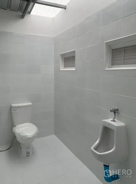 货栈 出租在Mueang Pathum Thani, Pathum Thani - 干净的卫生间，坐便器、尿斗与通风窗。