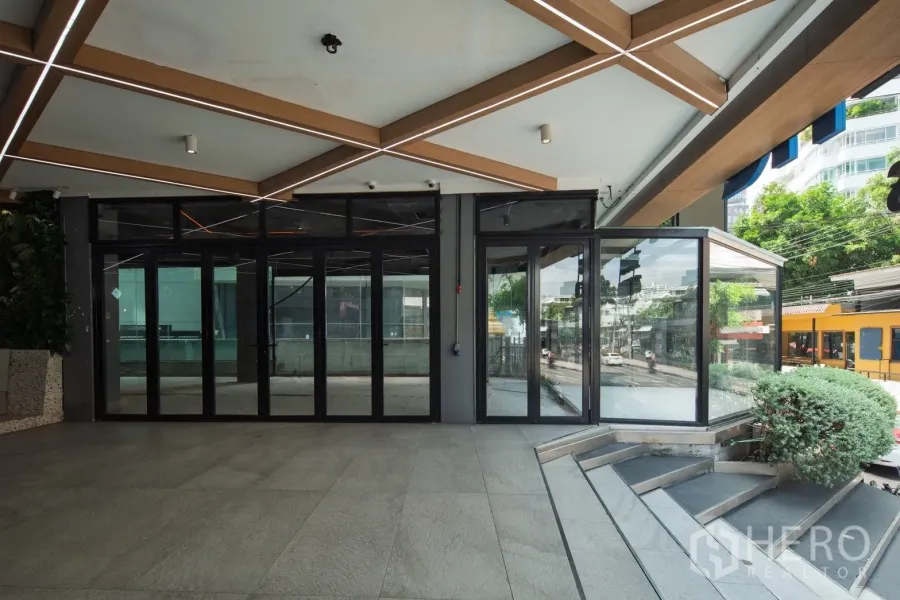 พื้นที่ขายปลีก ให้เช่าในKhlong Toei, Bangkok - หน้าร้านกระจกติดถนน ประตูพับ แสงไฟใต้กันสาด และบันได ข้าง BTS ทองหล่อ