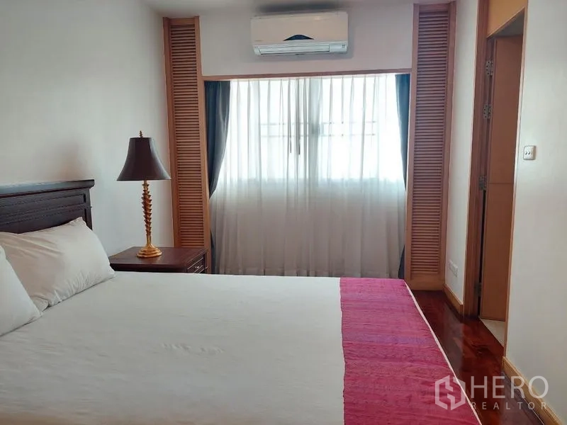 อพาร์ทเมนท์ ให้เช่า - ห้องนอนอบอุ่น มีเตียง หน้าต่างผ้าม่านโปร่ง และเครื่องปรับอากาศ