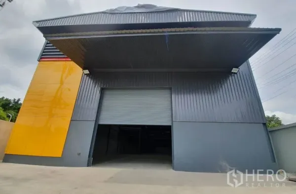 คลังสินค้า ให้เช่าในBang Khen, Bangkok - อาคารโกดังสมัยใหม่ ประตูม้วนขนาดใหญ่ หลังคากันสาดลึก พร้อมแผงสีเหลืองโดดเด่น