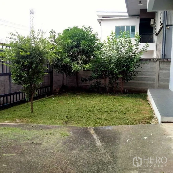 Warehouse for rent in Mueang Samut Sakhon, Samut Sakhon - Private fenced yard with a small lawn and trees beside the building.