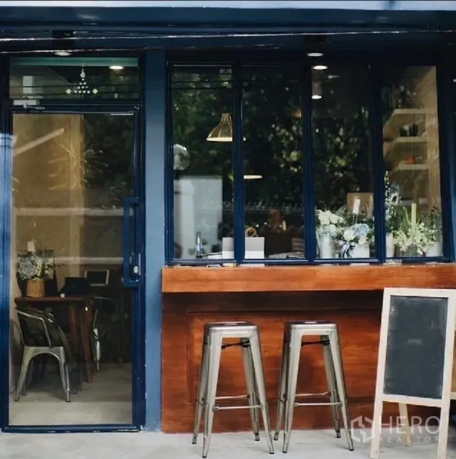 อาคารพาณิชย์ ให้เช่าในKhlong Toei, Bangkok - ด้านหน้าตึกแถวทันสมัย กรอบสีน้ำเงิน เคาน์เตอร์ไม้ และสตูลโลหะ