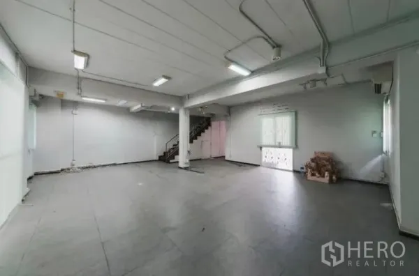 สำนักงานที่บ้าน ให้เช่าหรือขาย - ชั้นล่างพื้นที่ทำงานมีเสากลาง บันได ปูพื้นกระเบื้อง และหน้าต่างหลายบาน