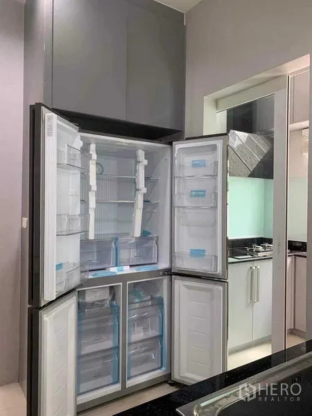 独立式住宅 出租在Bang Khen, Bangkok - 灰色厨房内的对开门大冰箱敞开展示空间。