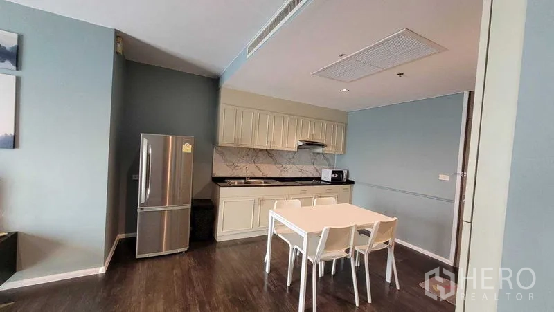 คอนโด ให้เช่าในKhlong Toei, Bangkok - ครัวแบบเปิด ตู้สีครีม แผงหลังลายหินอ่อน ตู้เย็นสแตนเลส และโต๊ะอาหาร