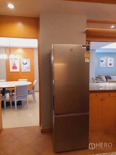 อพาร์ทเมนท์ ให้เช่า - ตู้เย็นสแตนเลสและมุมมองไปยังห้องอาหารโต๊ะกลมพร้อมโคมไฟแขวน