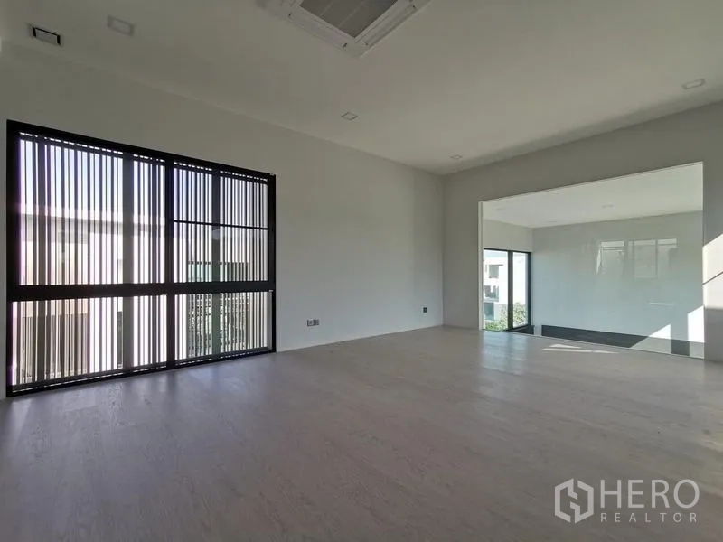 Detached House for rent or sale in Saphan Sung, Bangkok - Spacious upper-floor family room with pale wood flooring and a wide window.