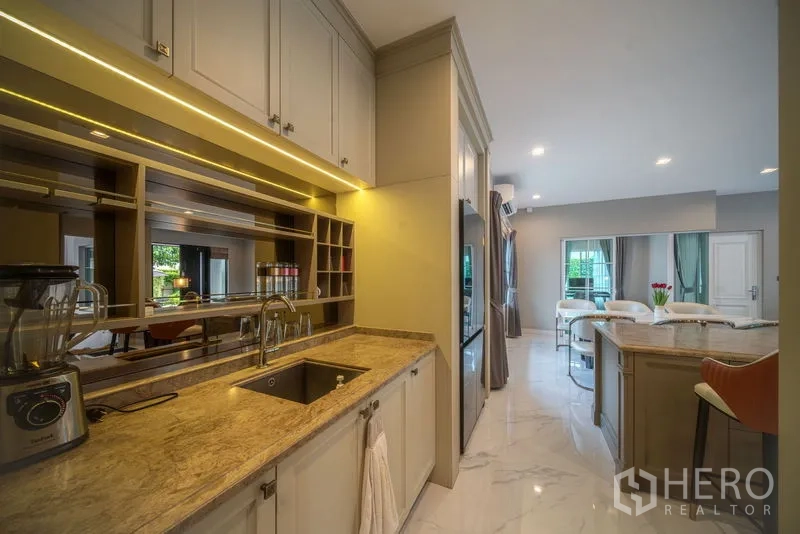 独立式住宅 出租在Bang Khen, Bangkok - 全配厨房，岛台、嵌入式橱柜、柜下灯带与大理石纹地面。