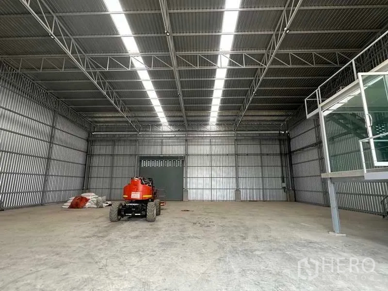 工厂 出租在Wang Noi, Phra Nakhon Si Ayutthaya - 无柱大空间仓库，屋顶采光带明显，内有曲臂升降机停放。