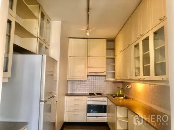 คอนโด ให้เช่าในWatthana, Bangkok - ครัวแยกตู้สีครีม ผนังกระเบื้อง เตาและเตาอบครบ