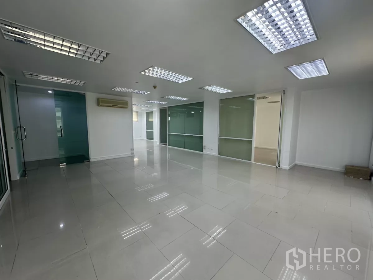 办公空间 出租在Huai Khwang, Bangkok - 宽敞工作区，多个玻璃会议室与磨砂隔断，格栅灯照明。