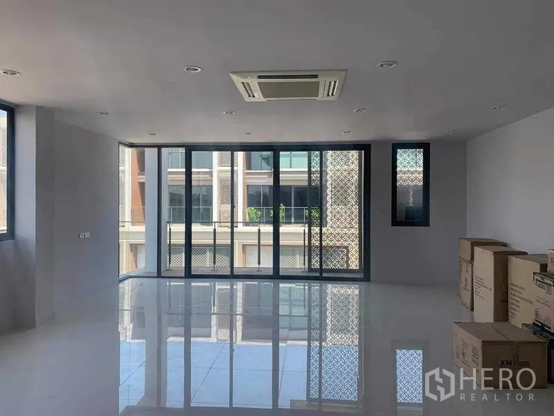 Townhouse for rent or sale in Yan Nawa, Bangkok - Large room with sliding glass doors to balcony and ceiling cassette air conditioner.