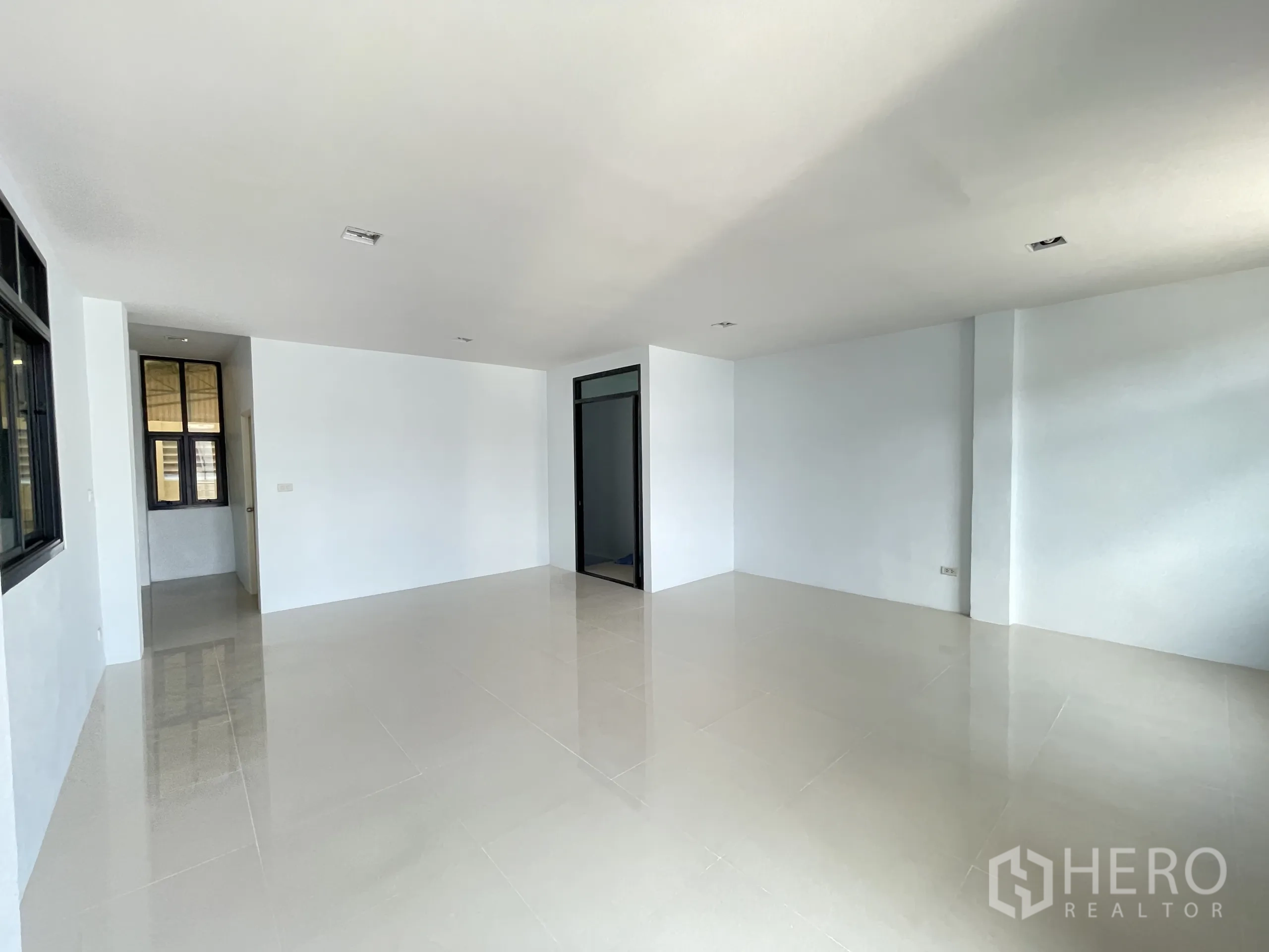 Factory for rent in Ban Phaeo, Samut Sakhon - Large flexible office room with windows and glossy tile floor.
