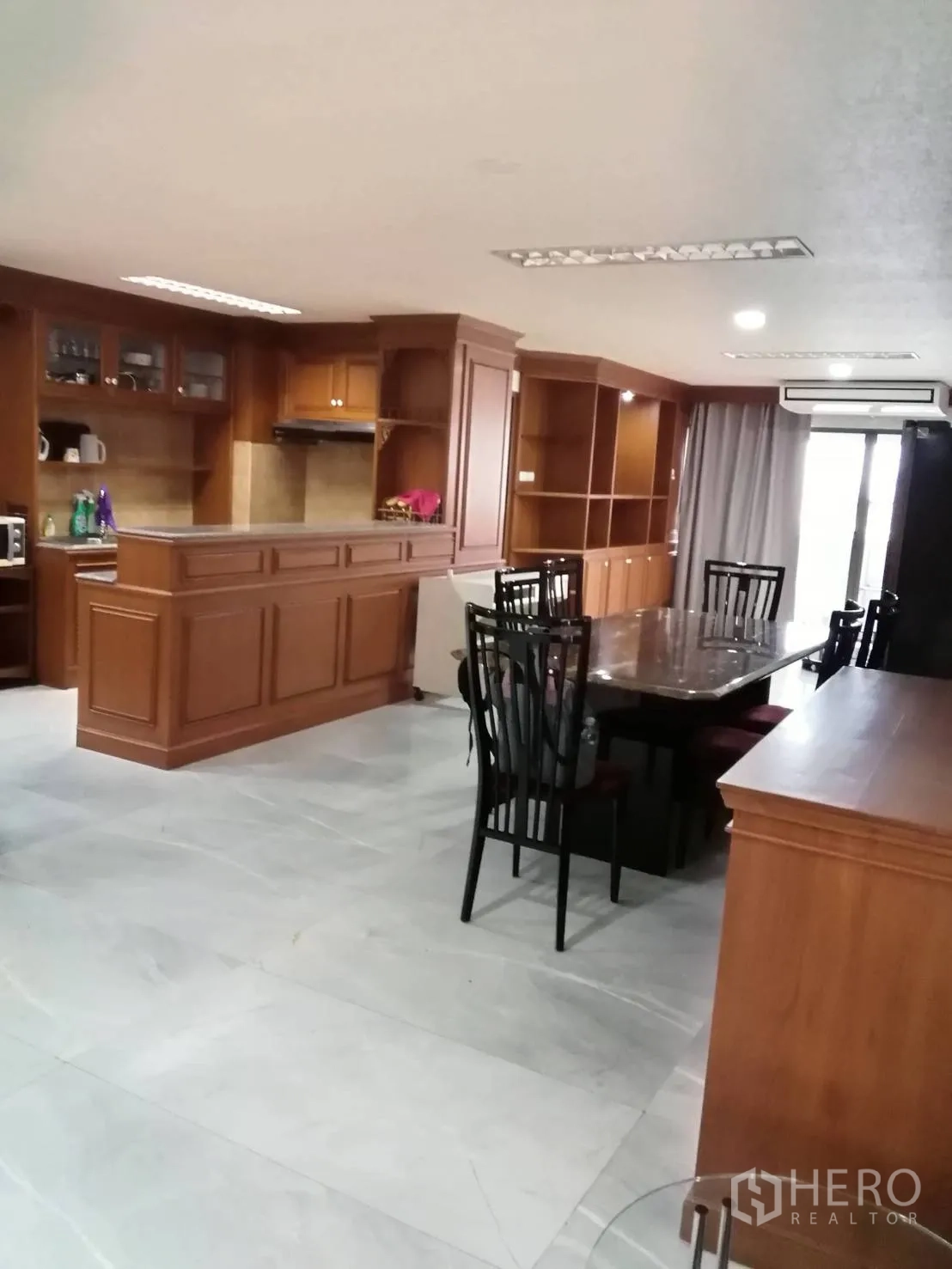 คอนโด ให้เช่าหรือขายในWatthana, Bangkok - โซนรับประทานอาหารและครัวแบบเปิดกับงานบิวท์อินไม้และโต๊ะทานข้าวขนาดใหญ่