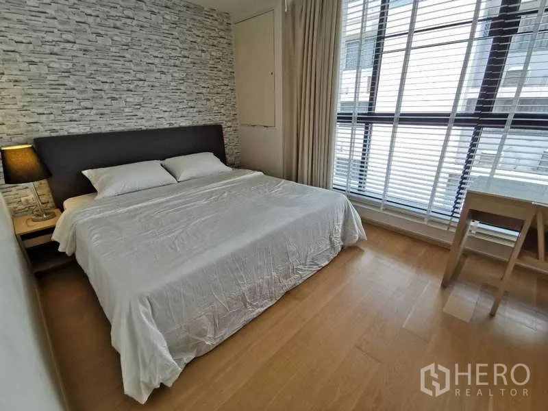 คอนโด ให้เช่าหรือขายในWatthana, Bangkok - ห้องนอนเตียงคิง ผนังลายหินและหน้าต่างสูงจรดเพดาน พร้อมโต๊ะทำงาน