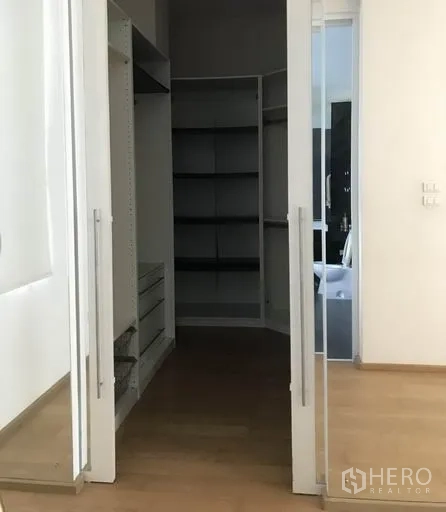 Detached House for sale in Suan Luang, Bangkok - Walk-in closet with built-in shelves viewed through sliding doors.