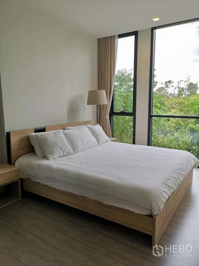 คอนโด ให้เช่าในWatthana, Bangkok - ห้องนอนที่สอง เตียงไม้ โคมไฟตั้งพื้น และหน้าต่างพาโนรามามองยอดไม้