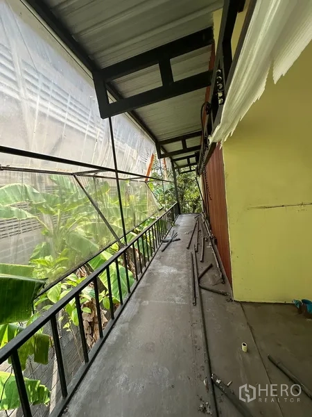 Detached House for rent in Watthana, Bangkok - Long upper-level room with many windows and exposed ceiling beams.