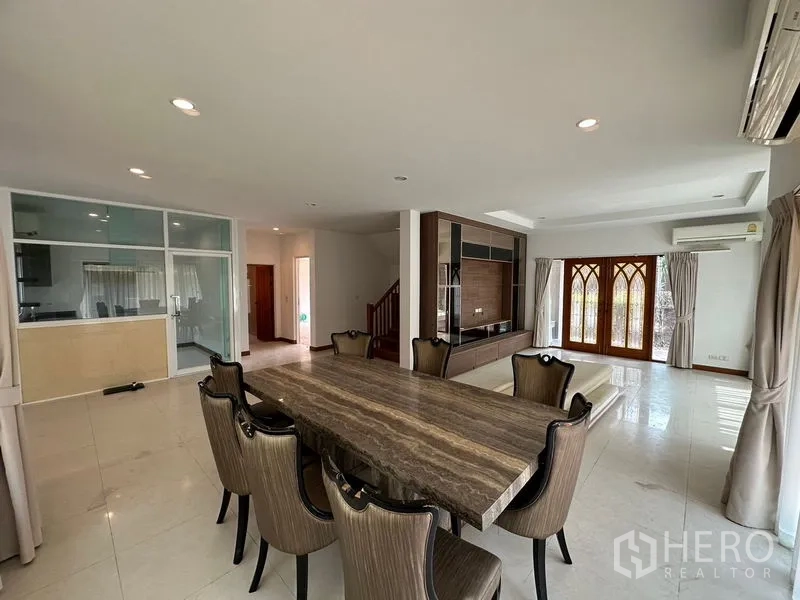 Detached House for rent or sale in Pak Kret, Nonthaburi - Bright open-plan living and dining area with marble table and built-in TV wall.