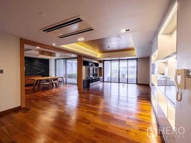 Condominium for sale in Yan Nawa, Bangkok - Expansive open‑plan living and dining space with lighted shelving and wide balcony access.