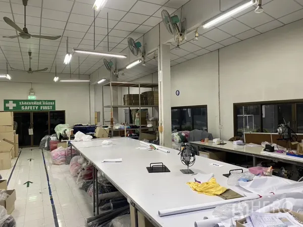 工厂 出租在Prawet, Bangkok - 高顶明亮的生产大厅，吊扇与长工作台