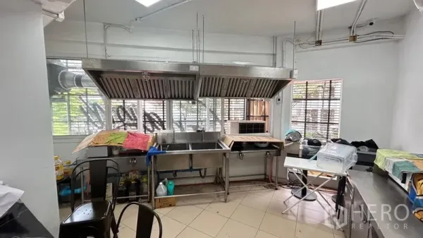 Shophouse for sale - Stainless commercial kitchen with twin extraction hoods and sink.