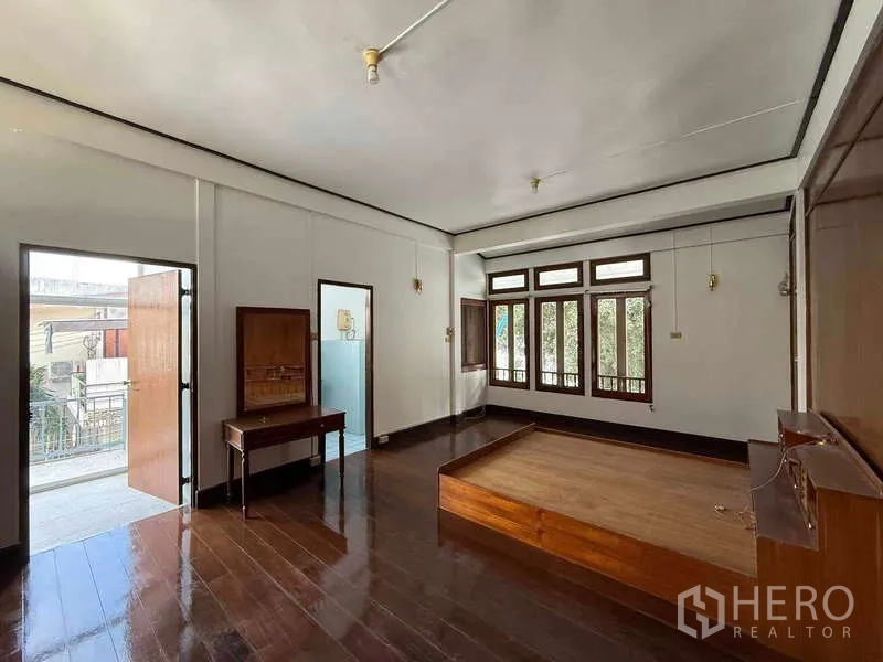 独立式住宅 出租在Watthana, Bangkok - 采光良好的卧室，木地板，带通往阳台的门和大窗。