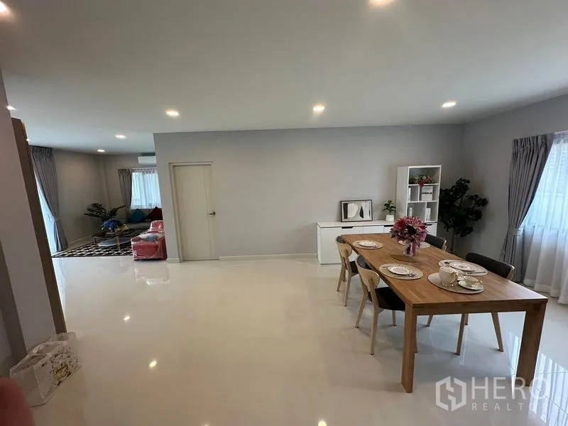 Detached House for rent in Bang Phli, Samut Prakan - Open-plan ground floor showing dining zone and adjacent living area with glossy tile flooring.