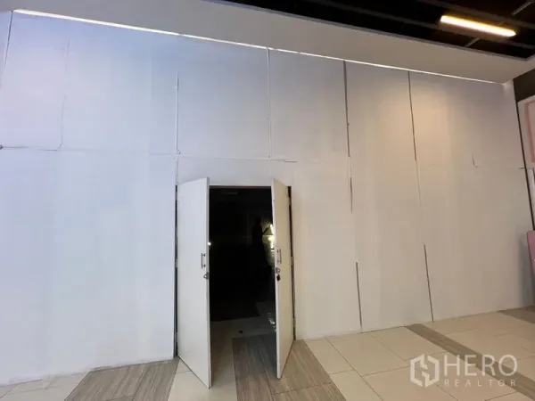 零售空间 出租 - 店铺门面配白色围挡，双开门敞开，通往室内零售空间。