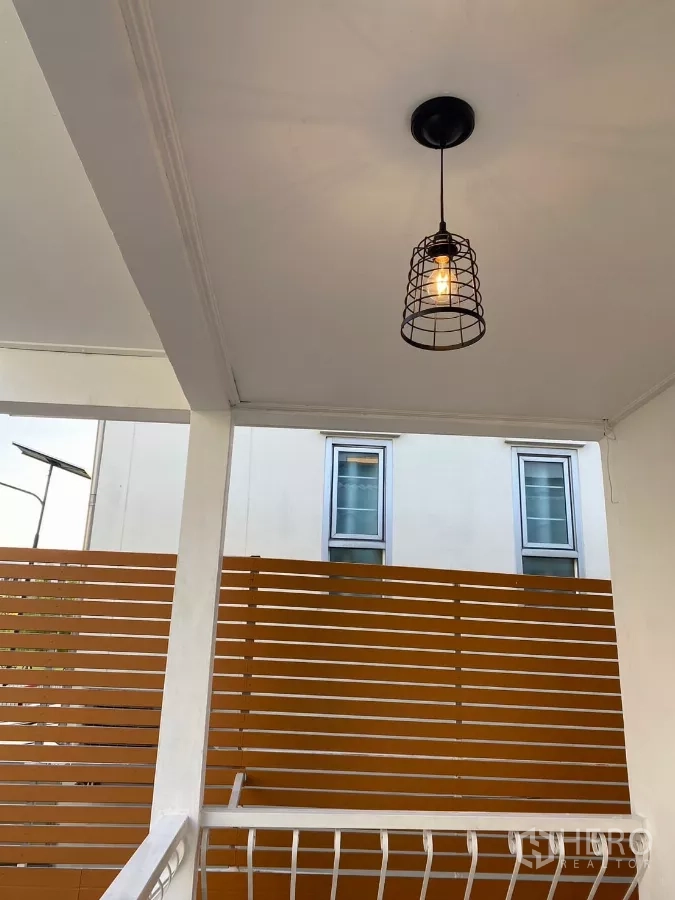 Detached House for rent in Bang Na, Bangkok - Covered side terrace with pendant light and horizontal wooden privacy screen.