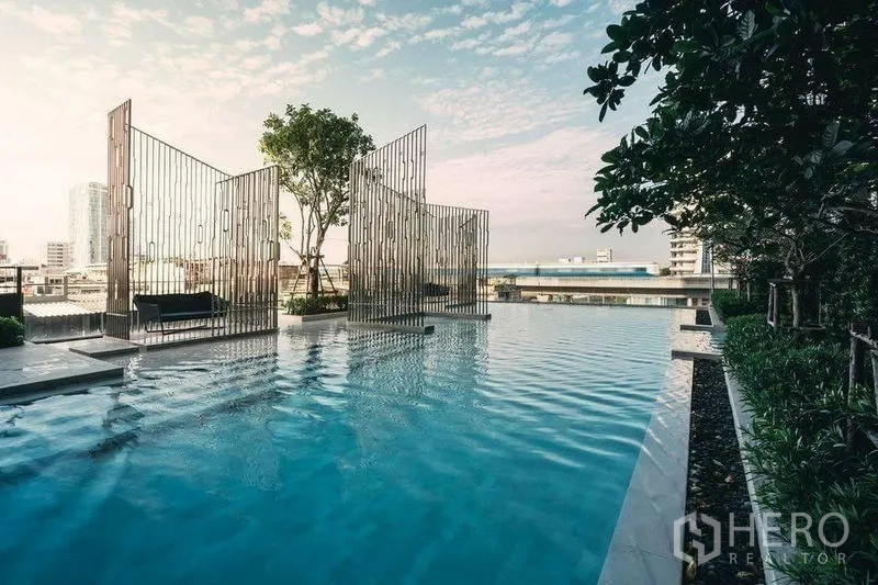Condominium for rent in Phra Khanong, Bangkok - Rooftop infinity-edge pool with city views and sculptural privacy screens.