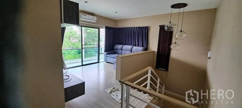 บ้าน ให้เช่าในLat Krabang, Bangkok - ห้องนั่งเล่นชั้นสองเชื่อมต่อระเบียง พร้อมราวบันไดและโคมไฟห้อย